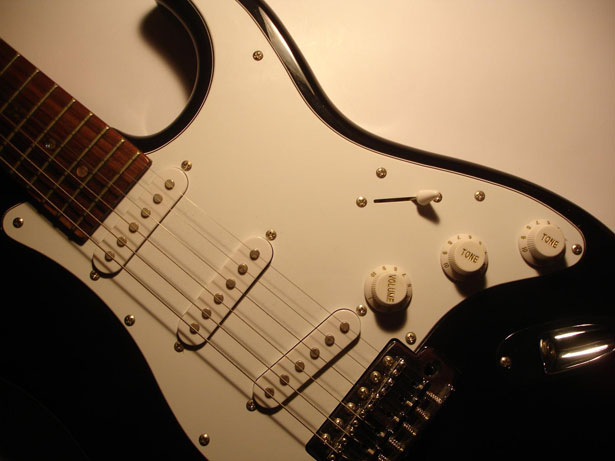 Guitar detail of strings over top the electronic pickups