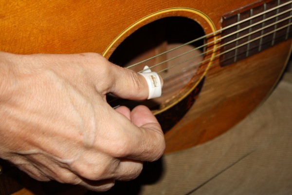 Thumb picking an acoustic guitar